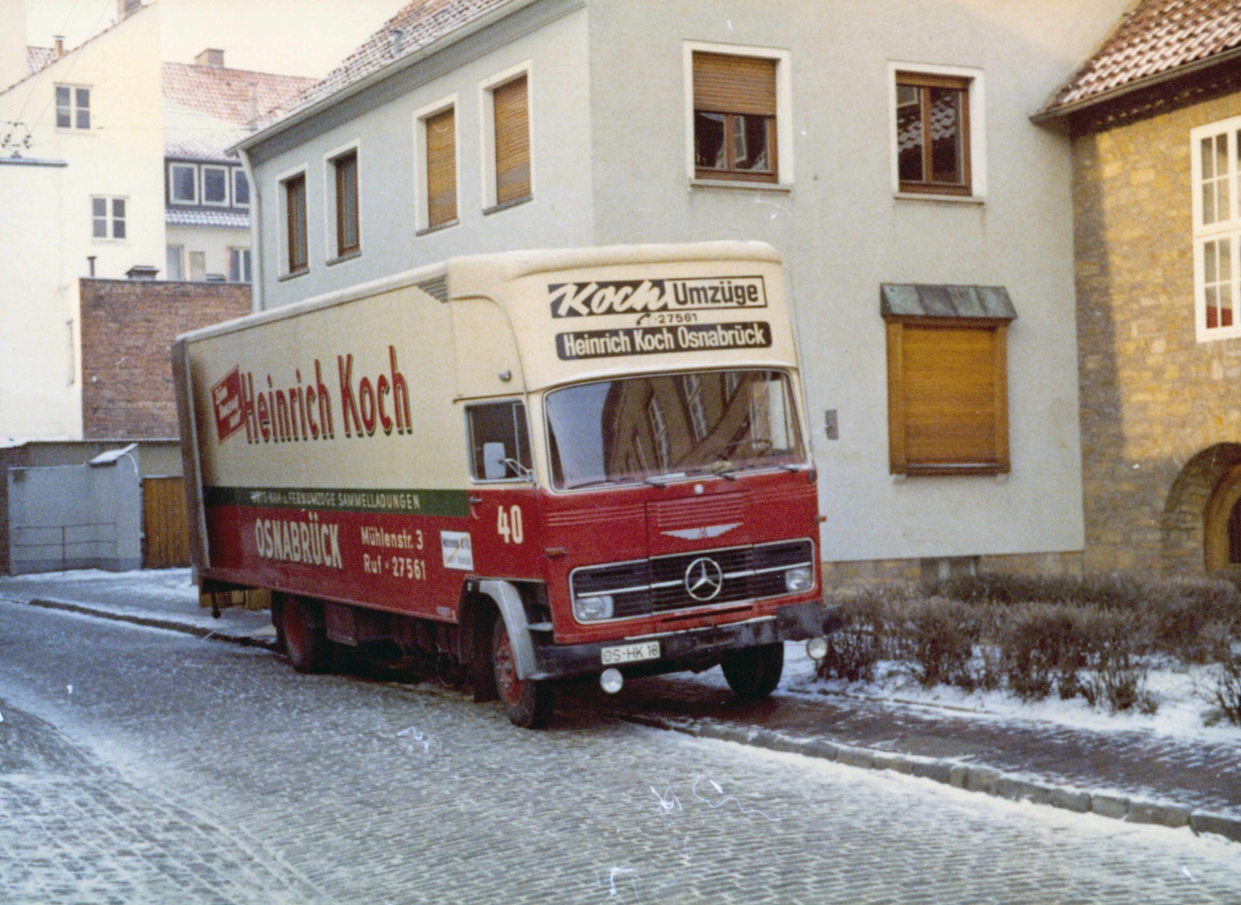 LKW von KOCH Umzugslogistik bei Wohnhaus – Über 125 Jahre Erfahrung in Osnabrück: Der Firmen-LKW im Einsatz vor einem Wohnhaus