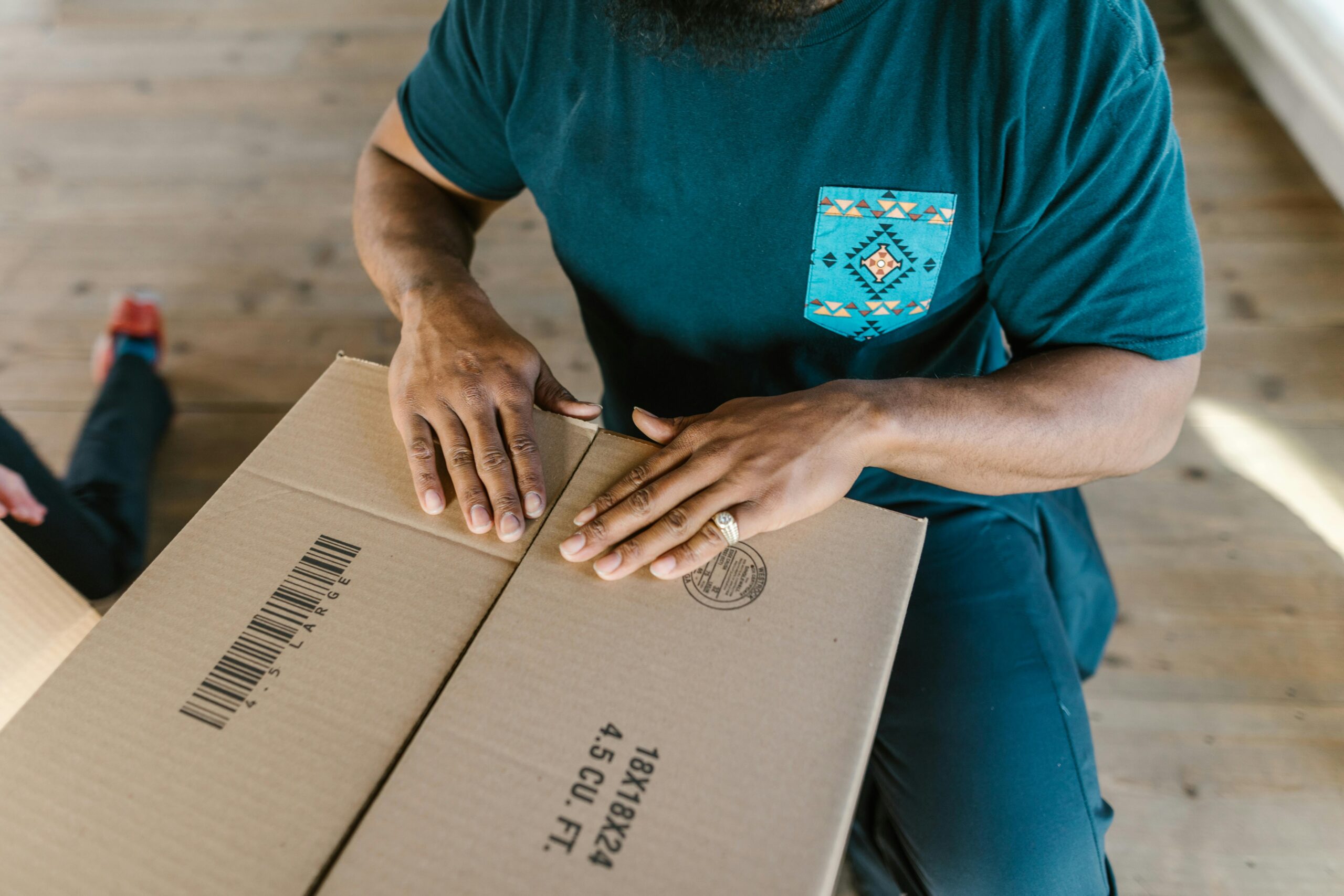 Verpacken beim Umzug – Mann füllt Kartons mit Geschirr und Büchern, Deutschland