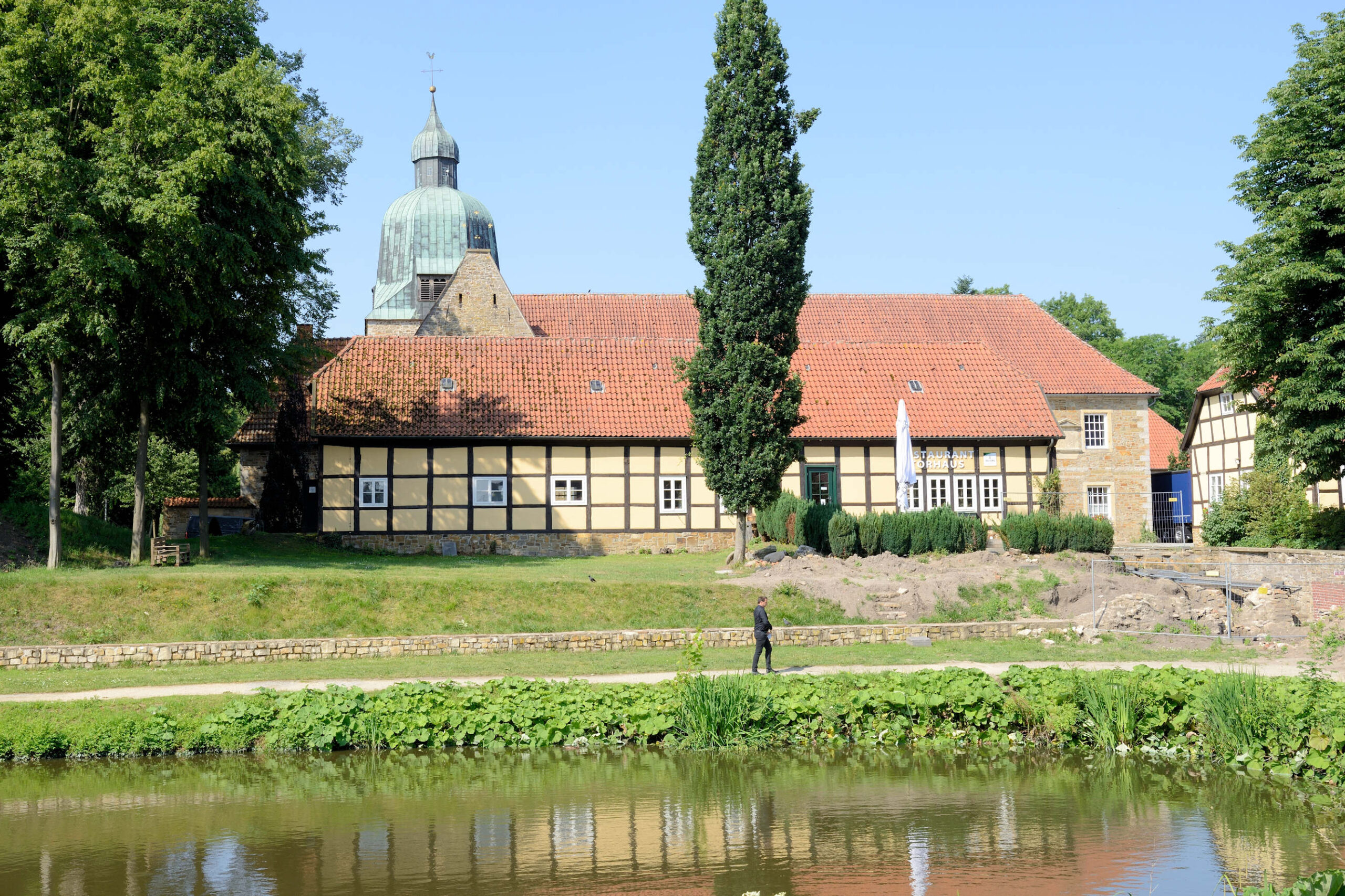 Historisches Fachwerkhaus am Wasser mit Kirchturm in Fürstenau.