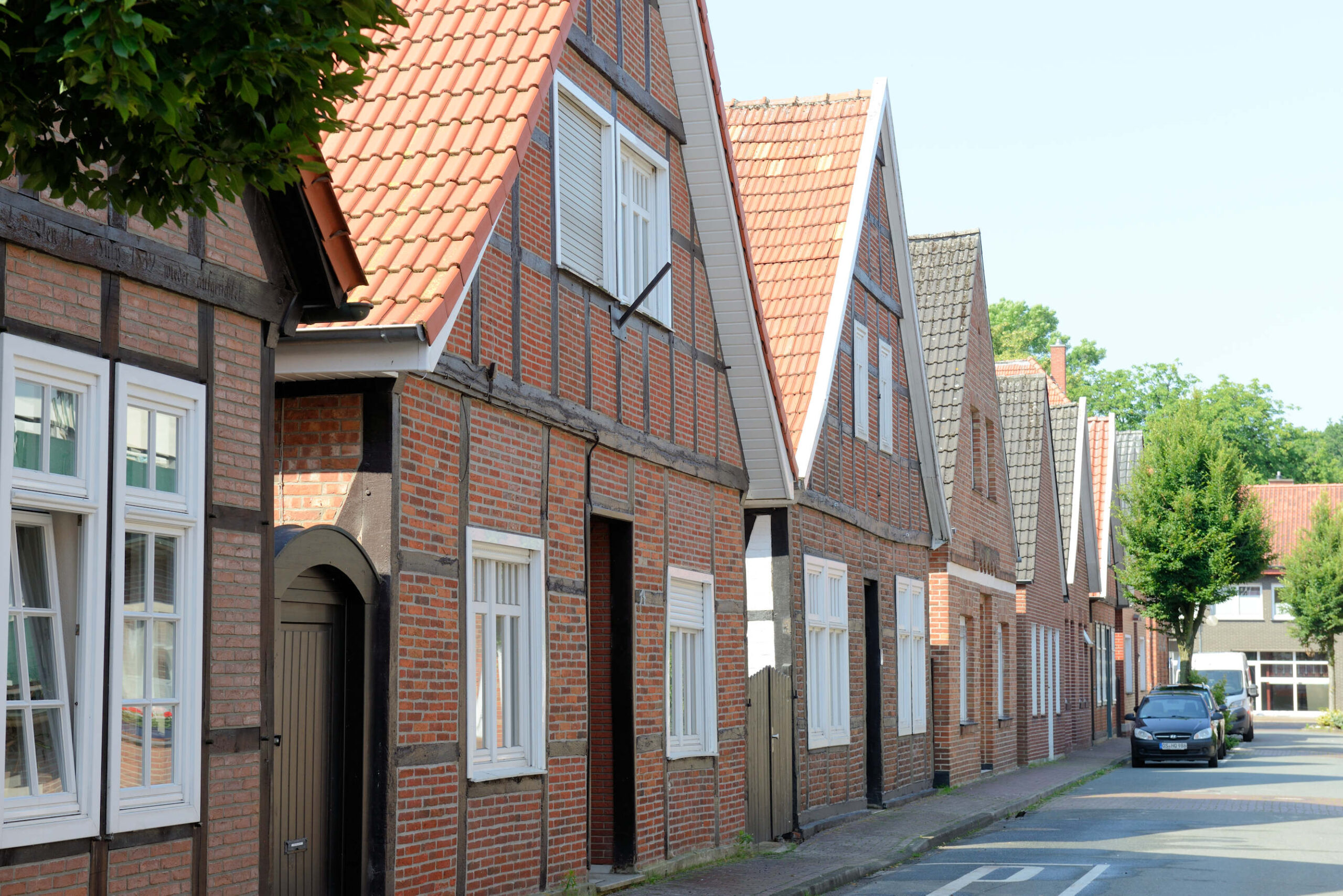 Traditionelle Backstein- und Fachwerkhäuser in einer Straße in Niedersachsen, Deutschland.