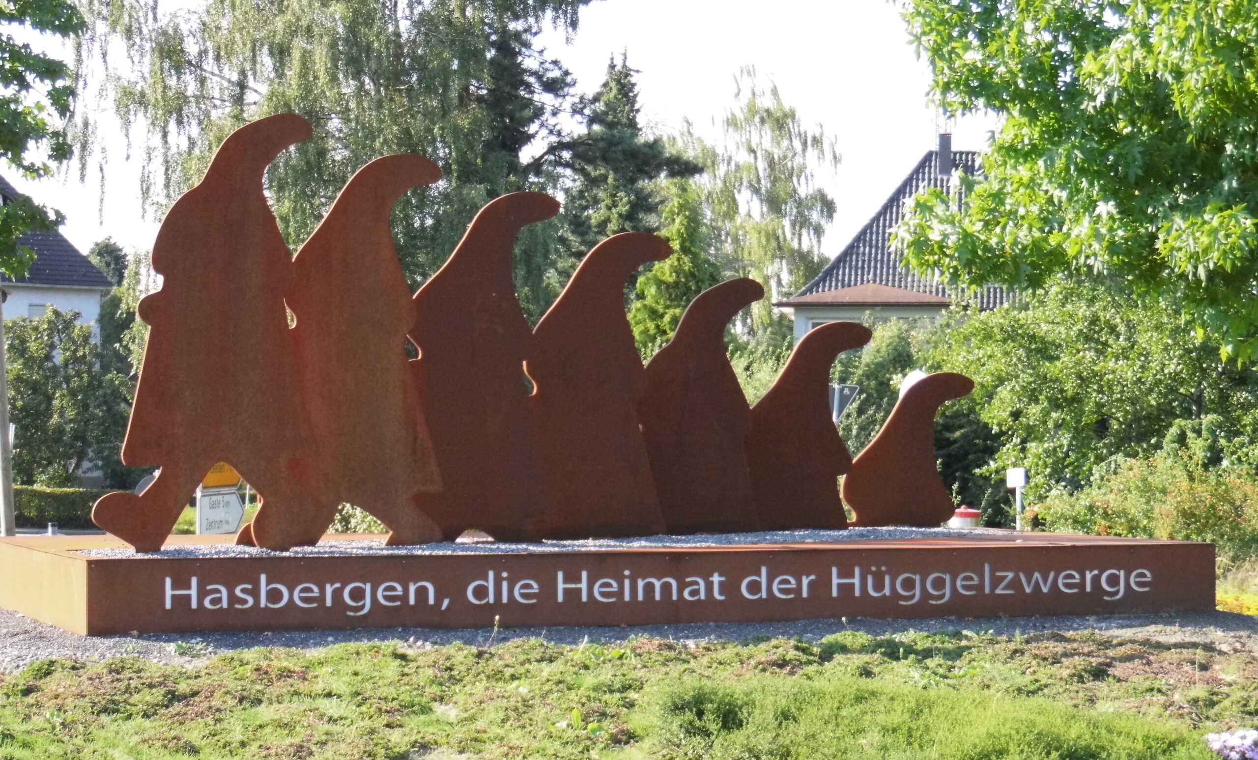 Ortseingangsschild mit Hüggelzwerge-Skulptur in Hasbergen