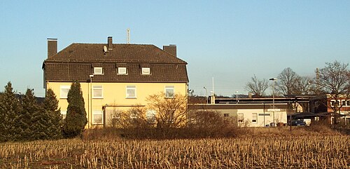 Haus am Feldrand mit Industrie- und Bahninfrastruktur in Lengerich.