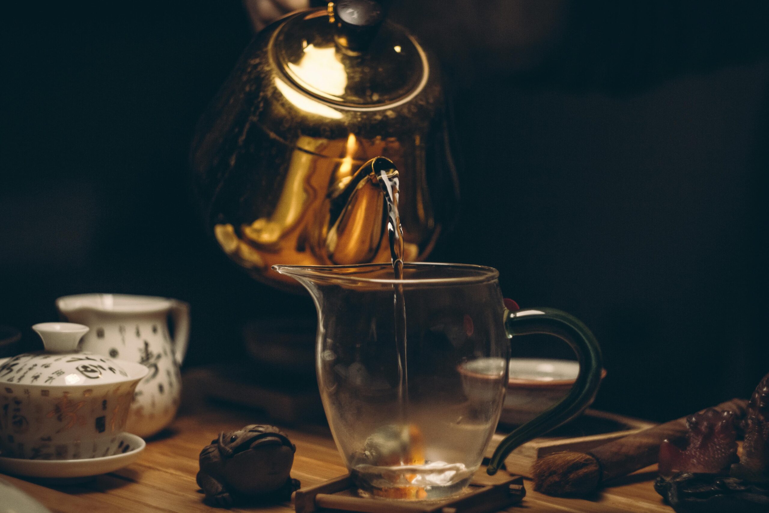 Zubereitung von traditionellem Tee mit Teekanne und Tasse mit chinesischen Schriftzeichen – Teekultur in China.