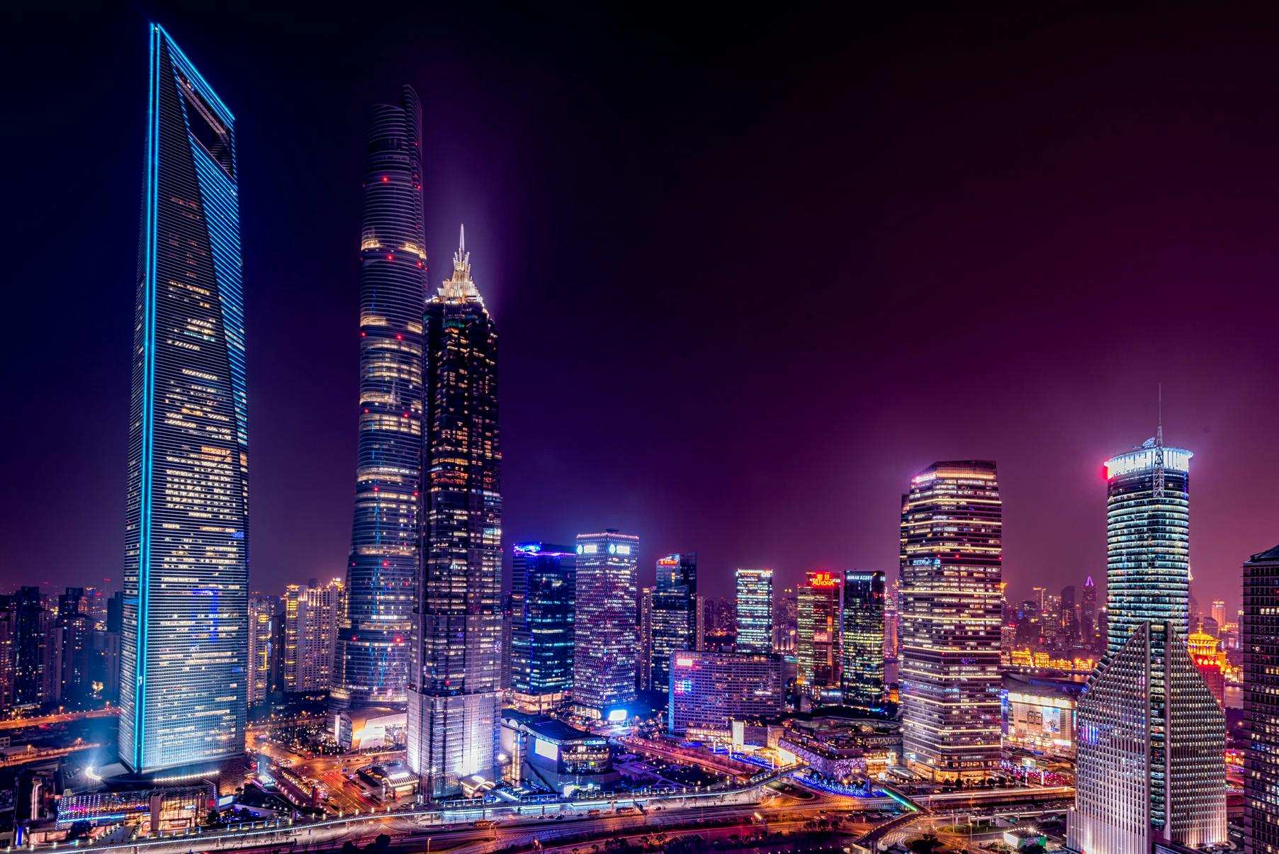 Moderne Wolkenkratzer der Metropole Shanghai in China bei Nacht – internationale Metropole für Expats und Unternehmen.