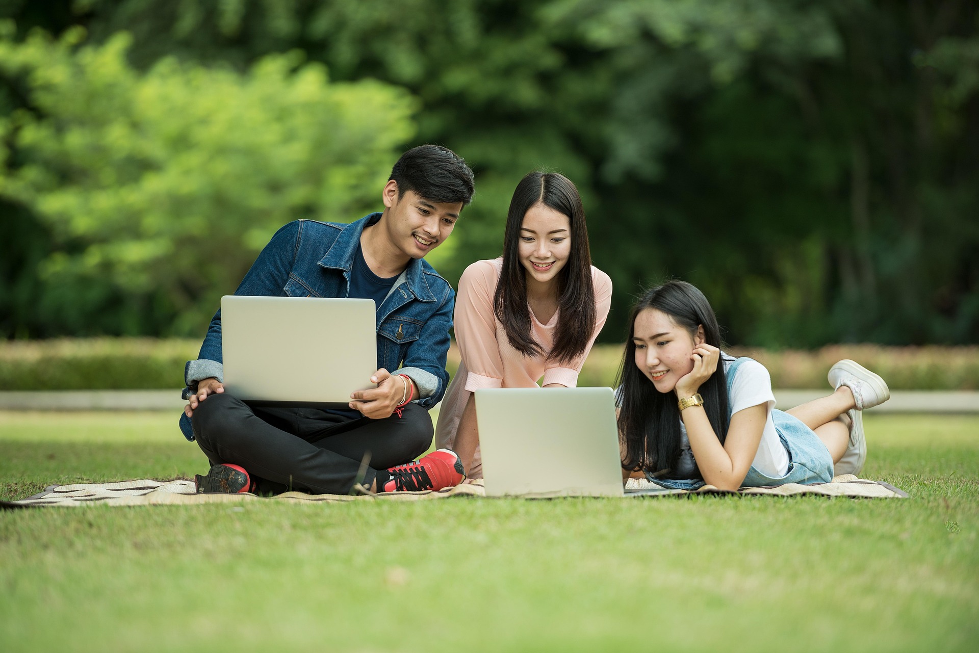 Junge Studierende unterwegs auf einem Universitätscampus mit Lernmaterialien in Thailand.
