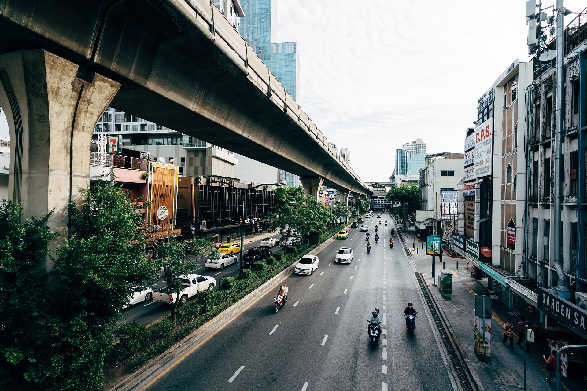 Autos auf einer urbanen Hauptstraße im Alltag einer Stadt in Thailand.