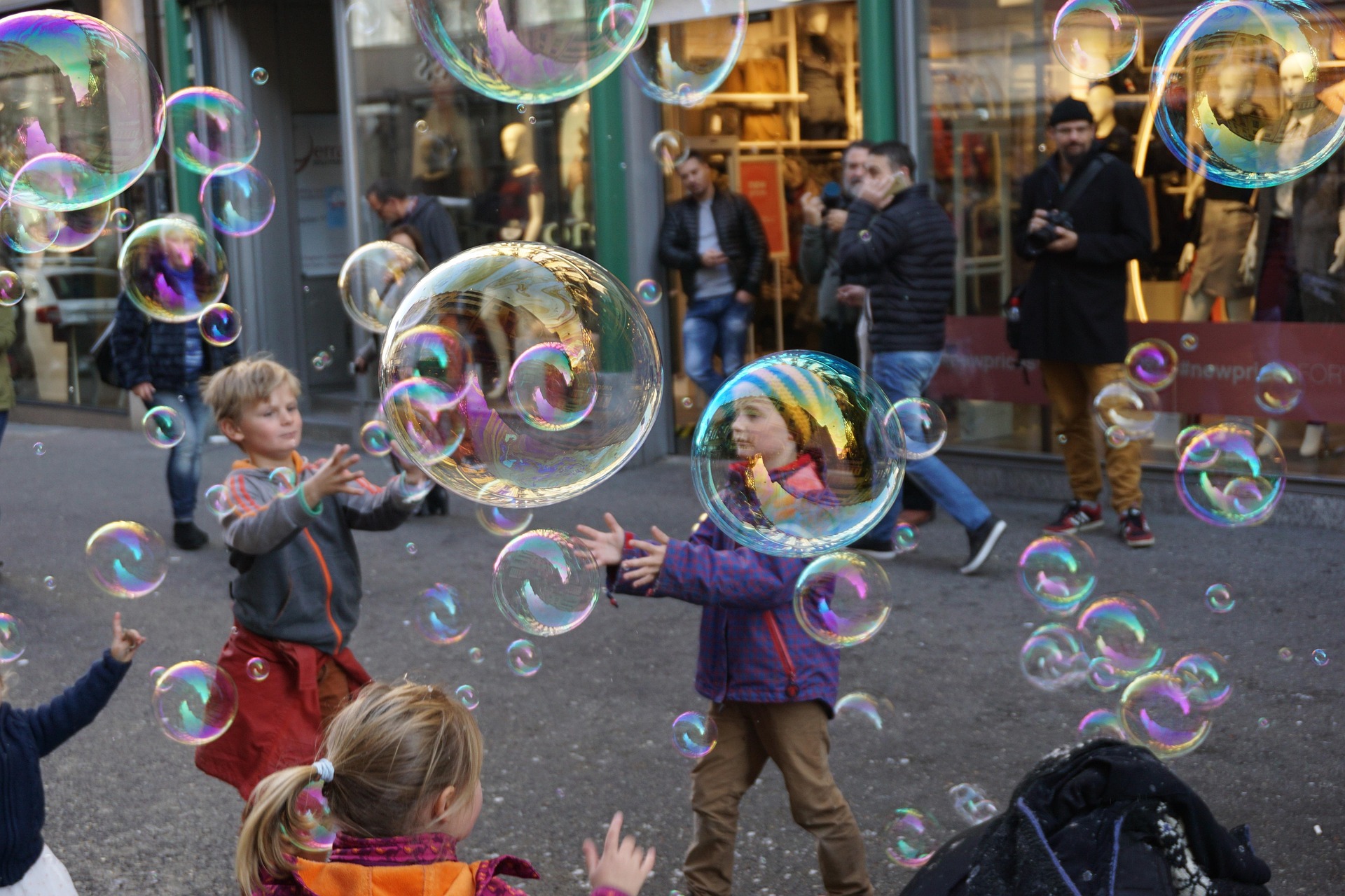 Kinder spielen auf der Straße mit Seifenblasen, Schweiz