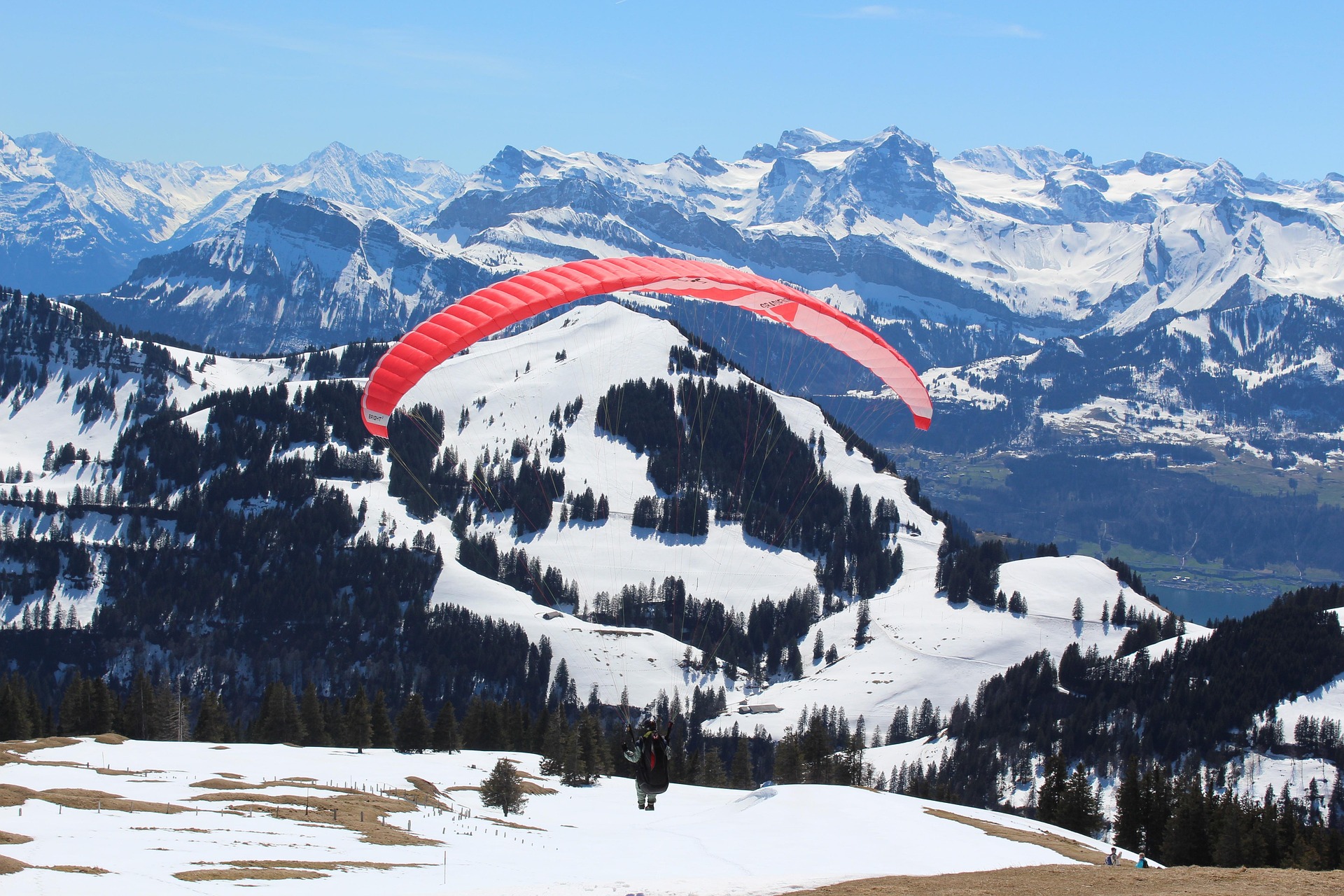 Paragleiter in den Alpen – Gleitschirmflieger über Schweizer Berglandschaft, Schweiz