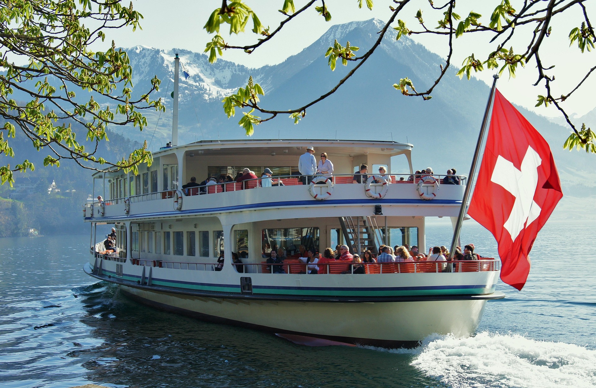 Schiff auf Schweizer Bergsee mit Schweizer Flagge – Passagierschiff auf glasklarem See, Schweiz