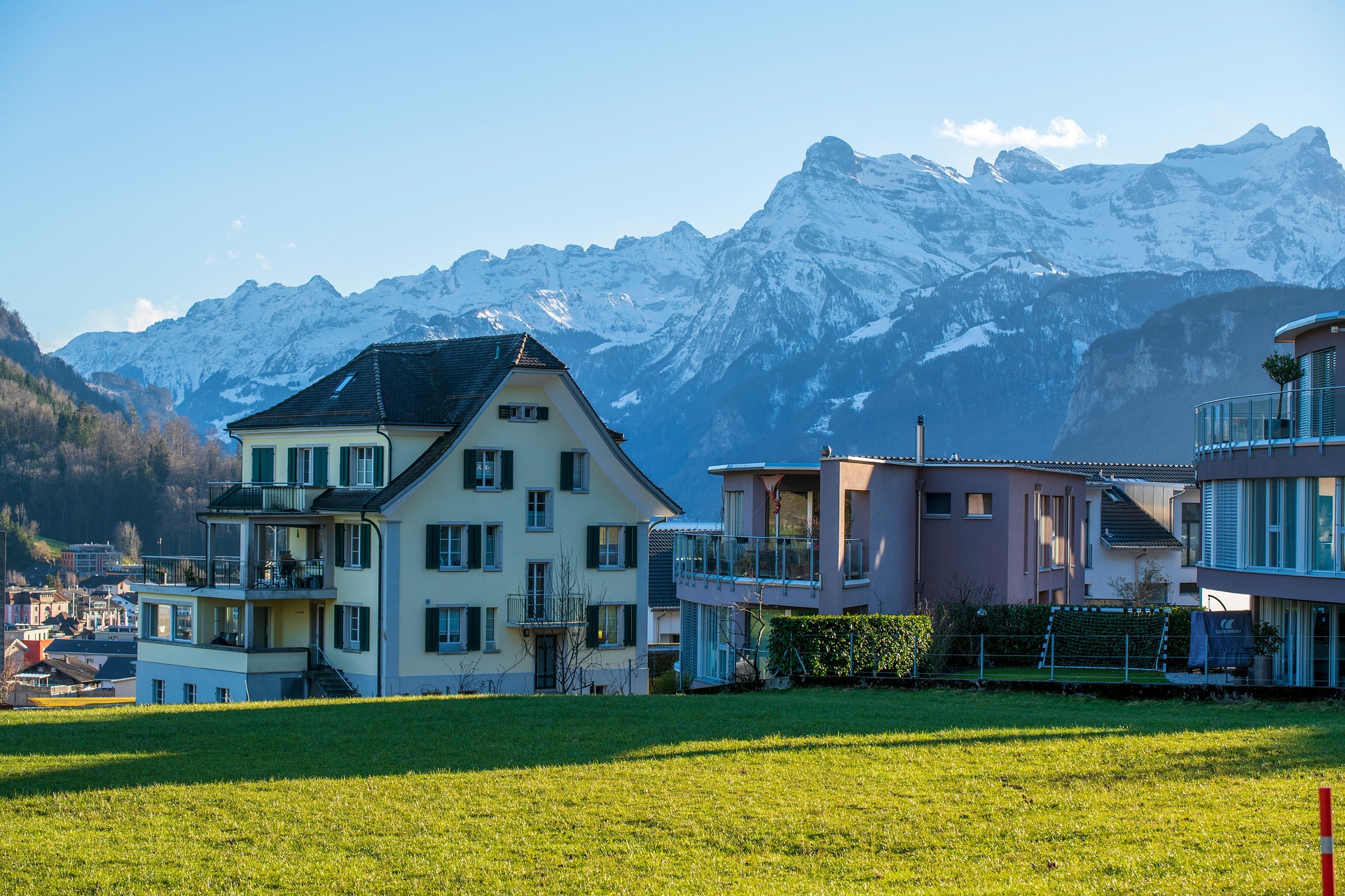 Wohnhäuser mit Alpenpanorama – Schweizer Siedlung vor Bergkulisse, Schweiz