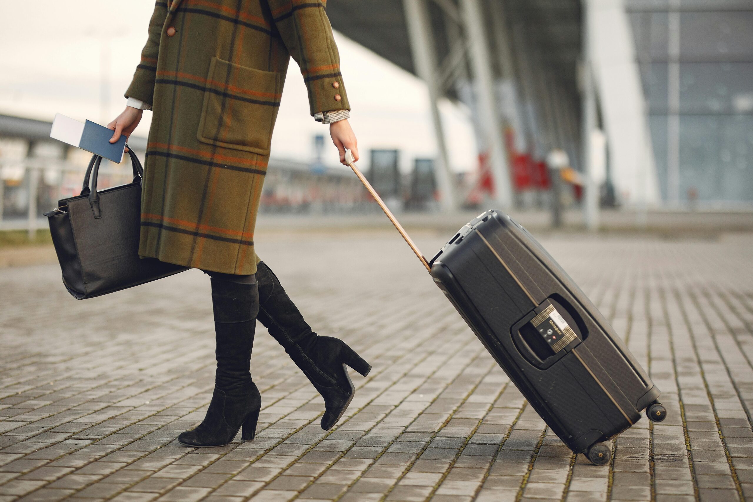 Eine Frau mit ihrem Gepäck – Frau beim internationalen Umzug mit ihrem Koffer und ihrer Tasche