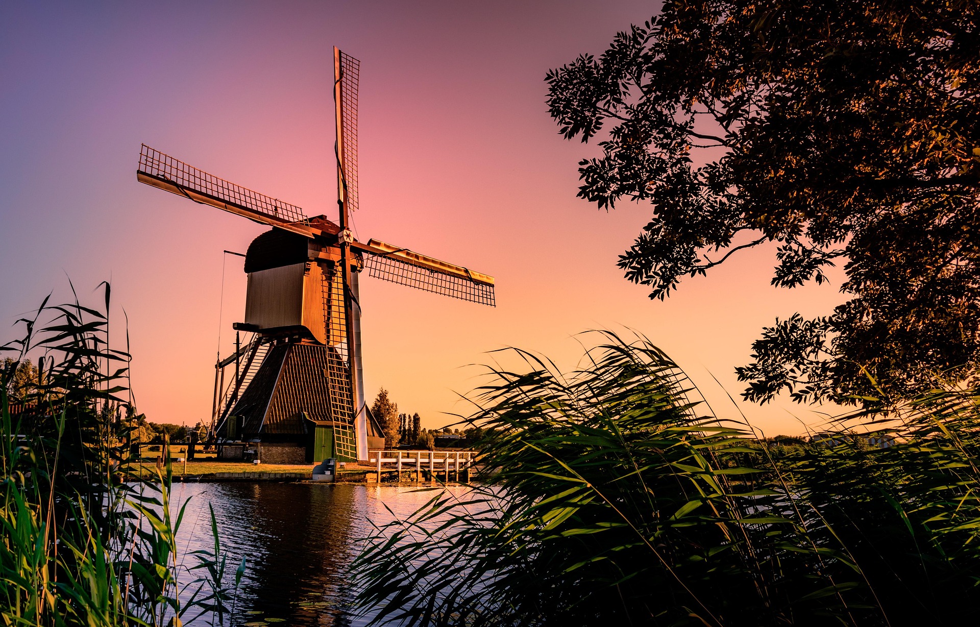 Windmühle in den Niederlanden bei Sonnenuntergang – Traditioneller Holländer-Windmühle am Wasser mit Abendrot, Niederlande