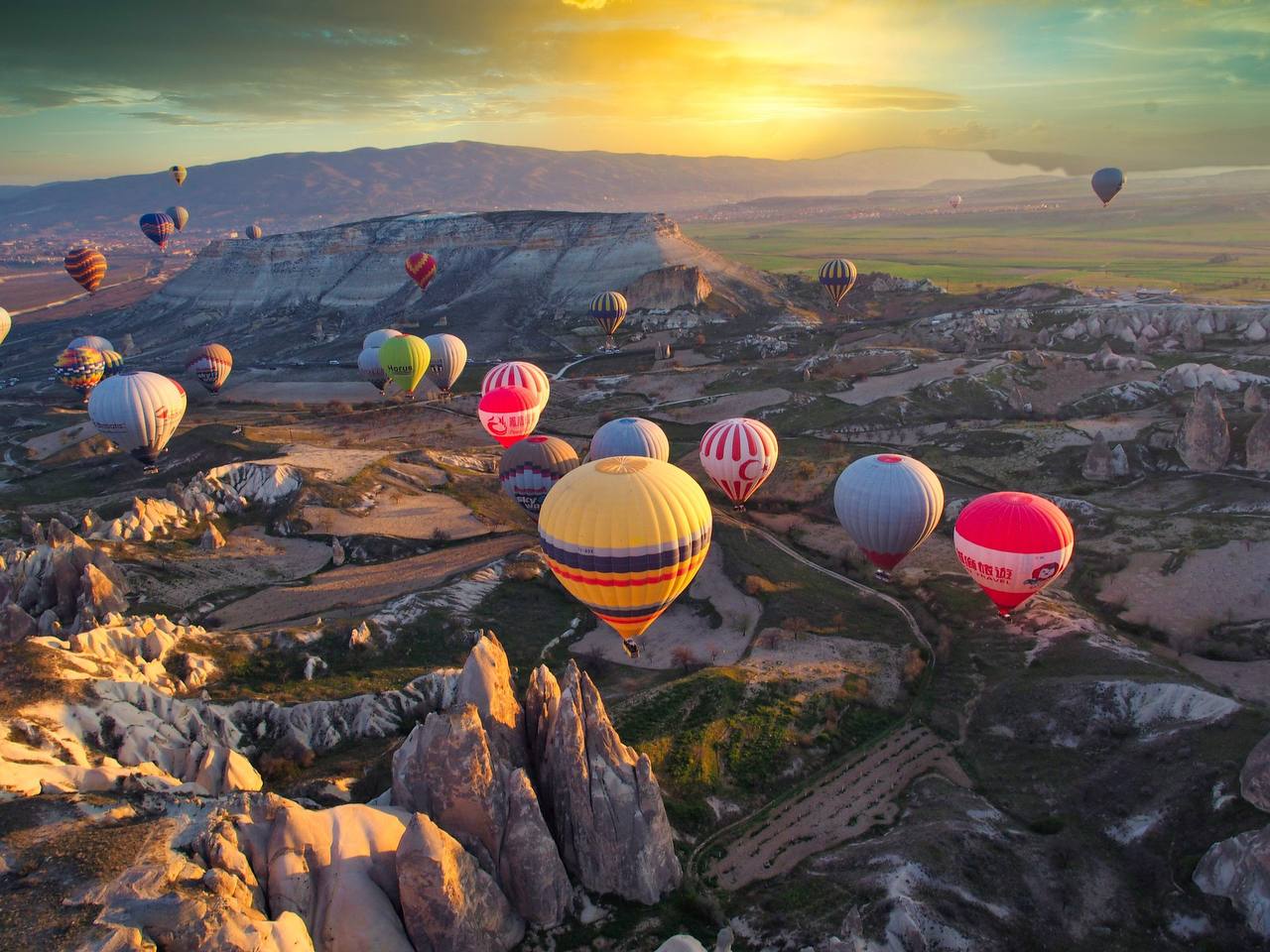 Kappadokien – Heißluftballons über Feenkaminen bei Sonnenuntergang, Türkei