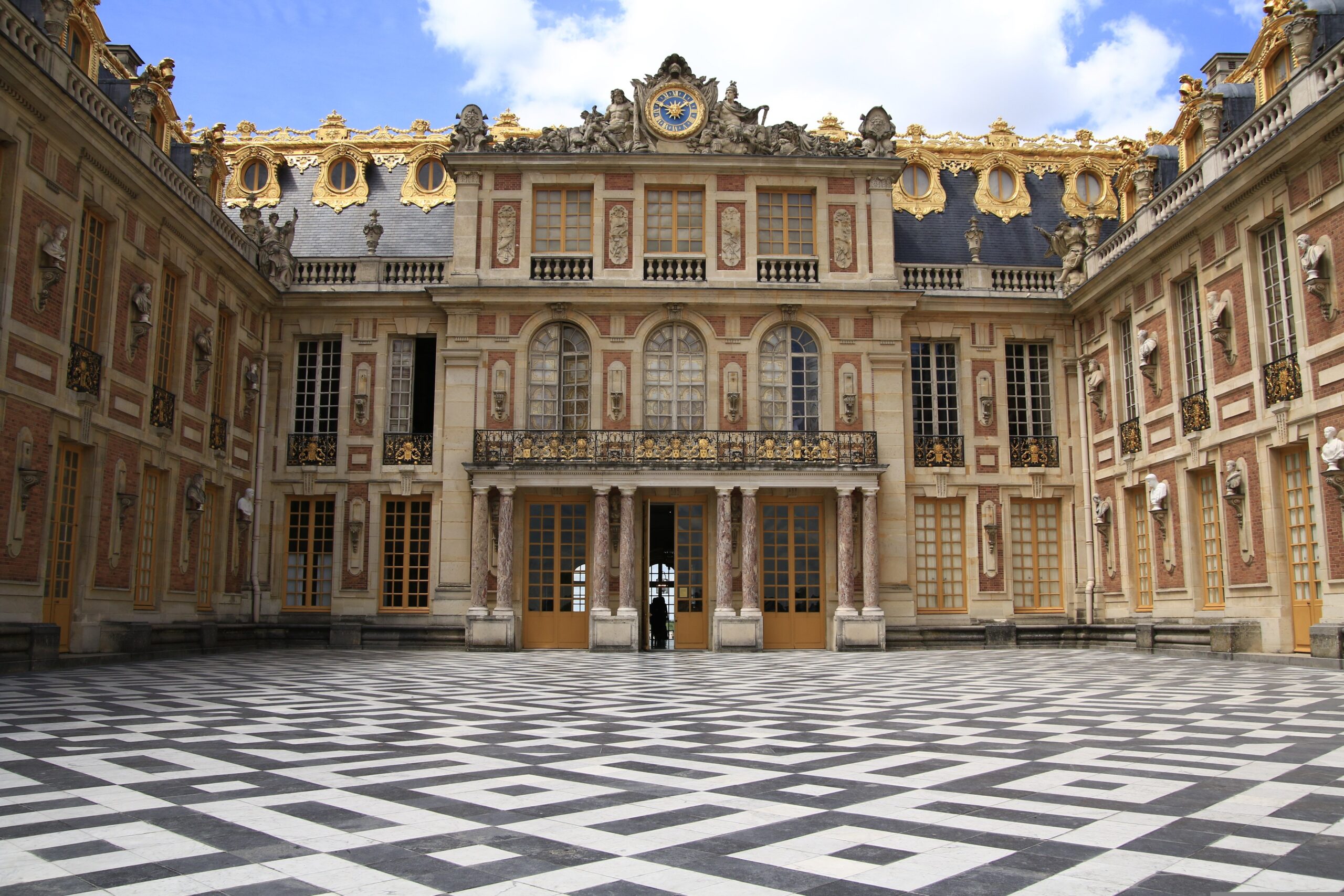 Château de Versailles – Prächtige Schlossfassade mit goldenen Ornamenten vor blauem Himmel, Frankreich