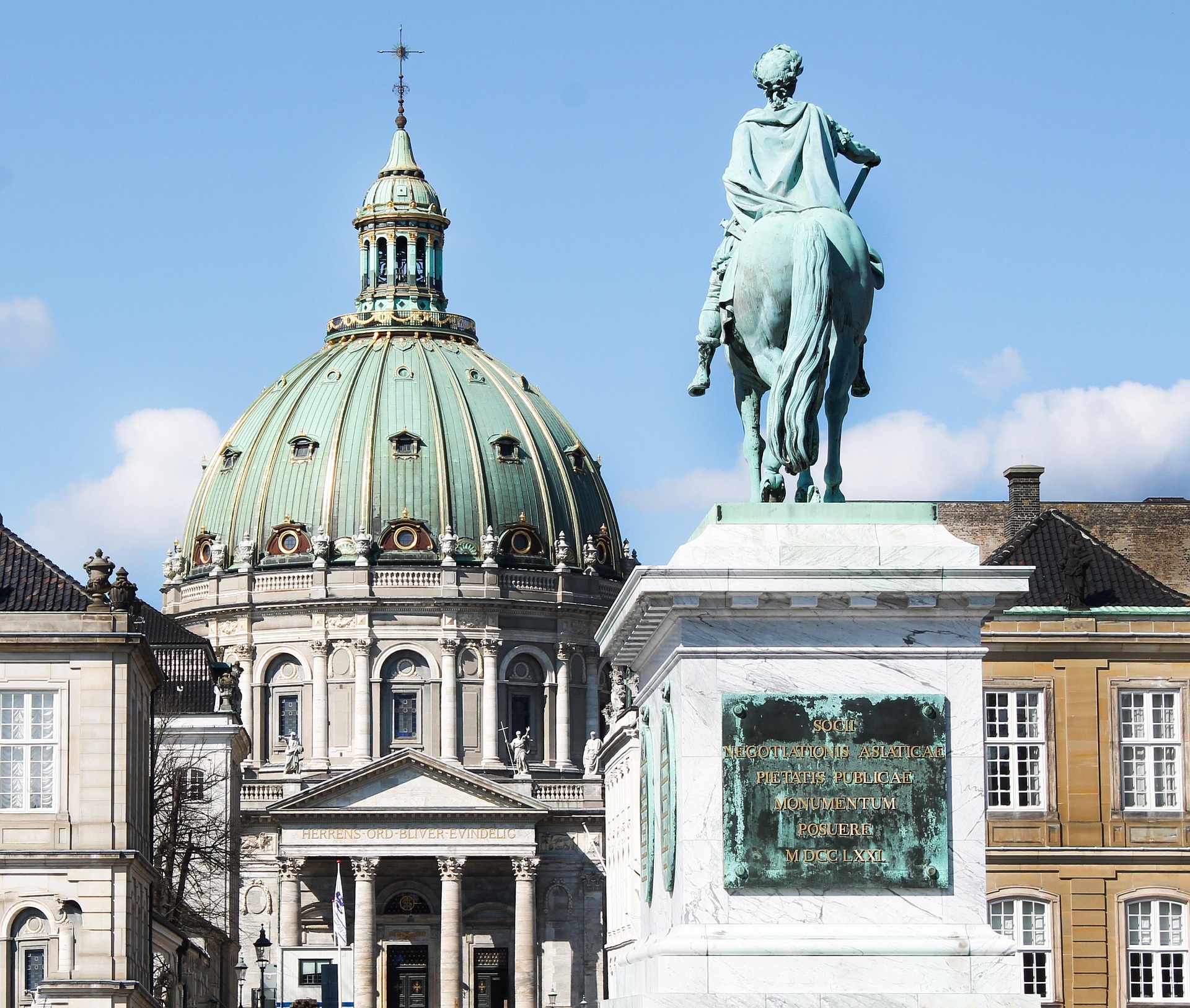 Reiterstandbild vor der Kuppelkirche Frederiks Kirke (Marmorkirche) in Kopenhagen, Dänemark, mit historischer Architektur und klarem blauem Himmel.