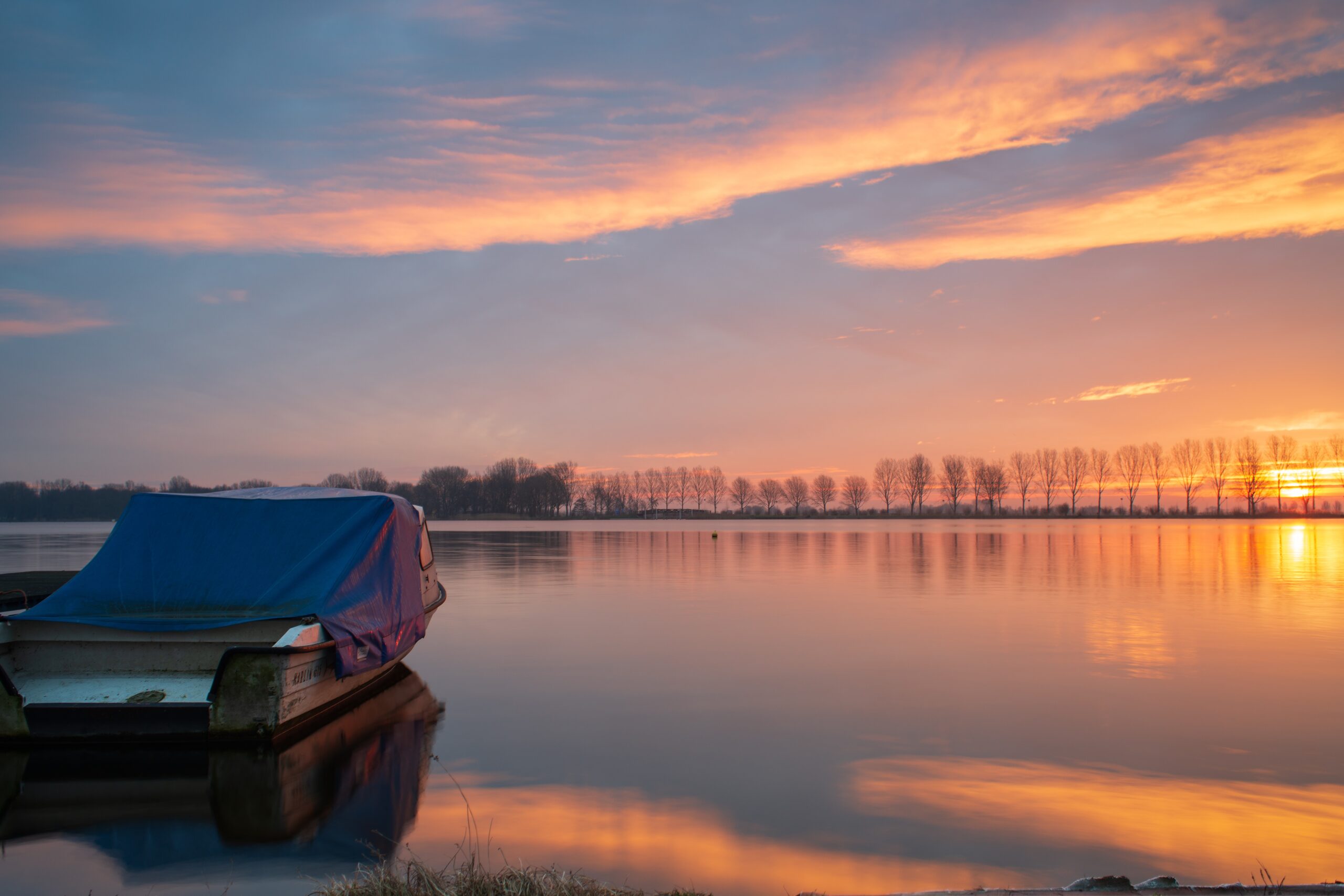 Boot am Fluss bei Sonnenuntergang – Abendstimmung auf niederländischem Gewässer, Niederlande