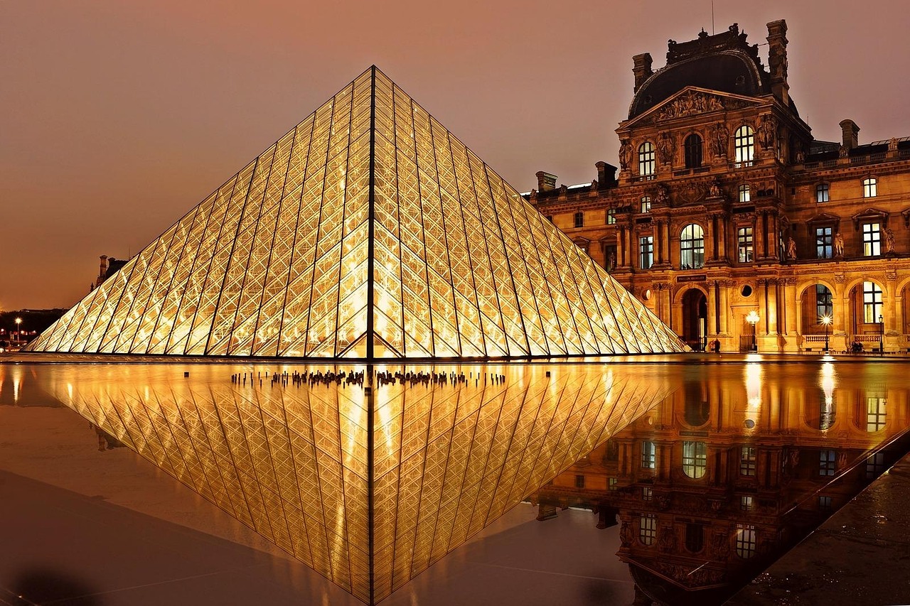 Louvre Paris bei Nacht – Beleuchtete Glaspyramide im Innenhof des Musée du Louvre, Frankreich