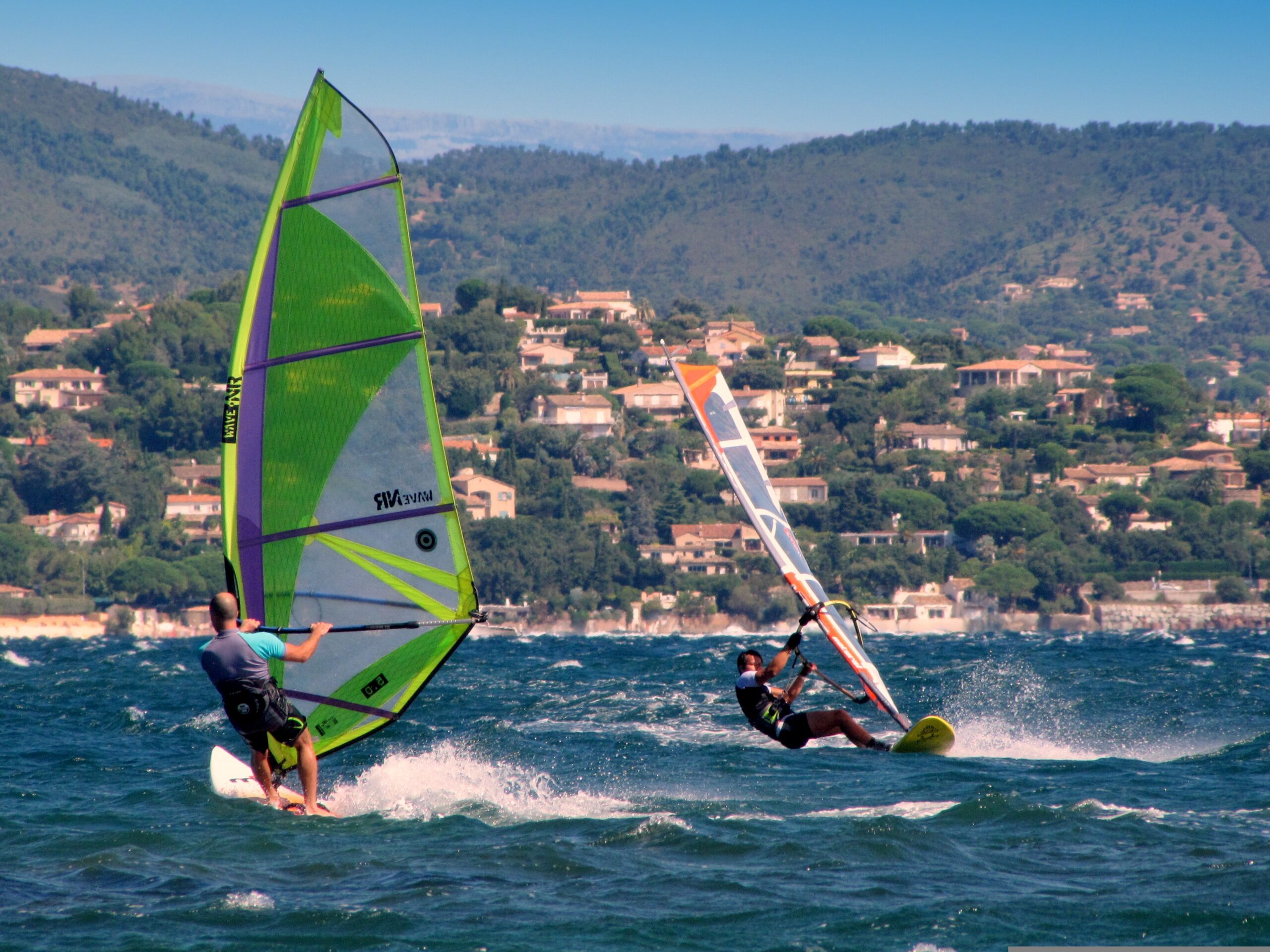 Windsurfen St. Tropez – Surfer auf dem Mittelmeer mit Küste im Hintergrund, Frankreich
