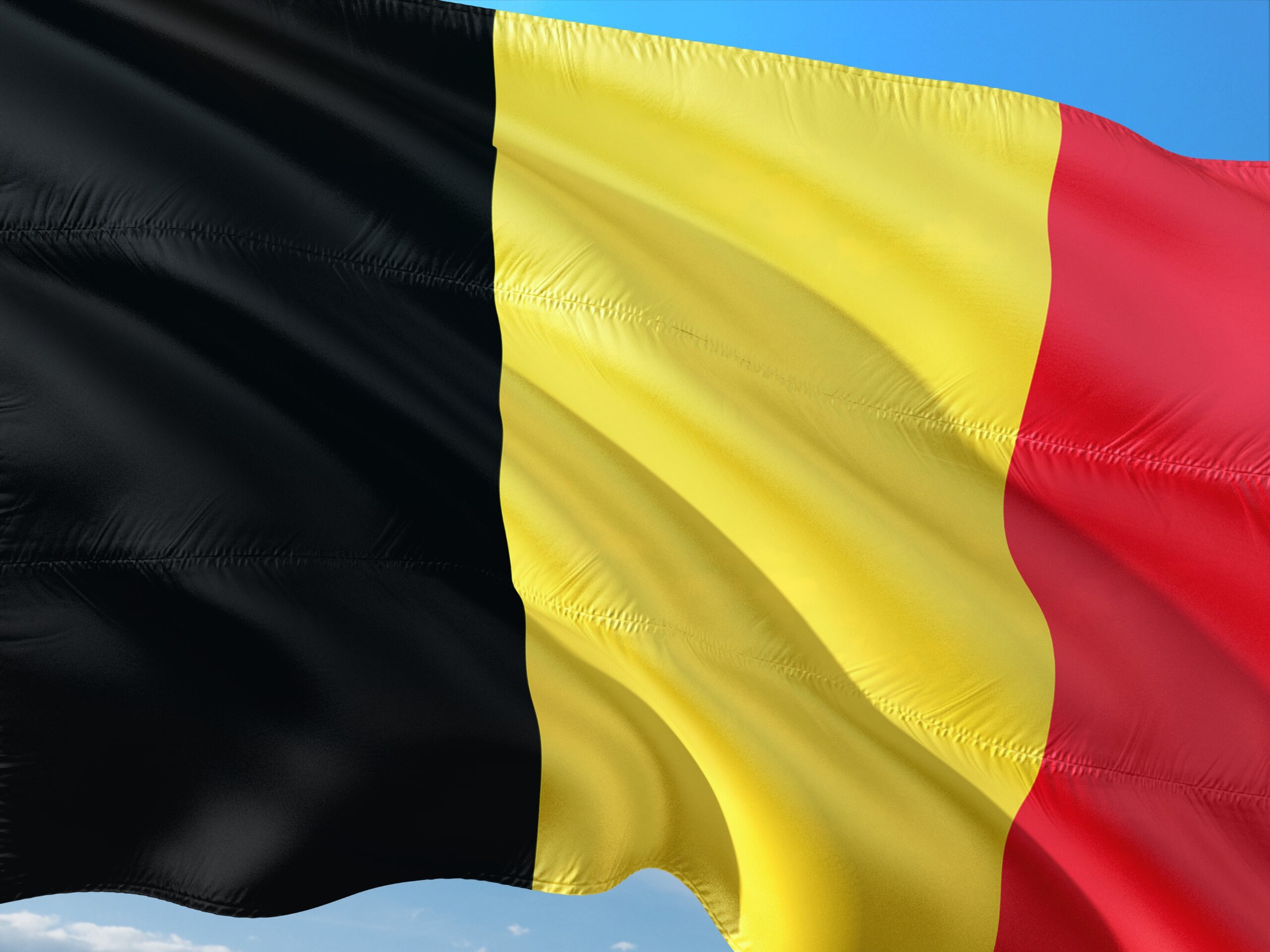 Belgien – Wehende Landesflagge vor blauem Himmel, Belgien