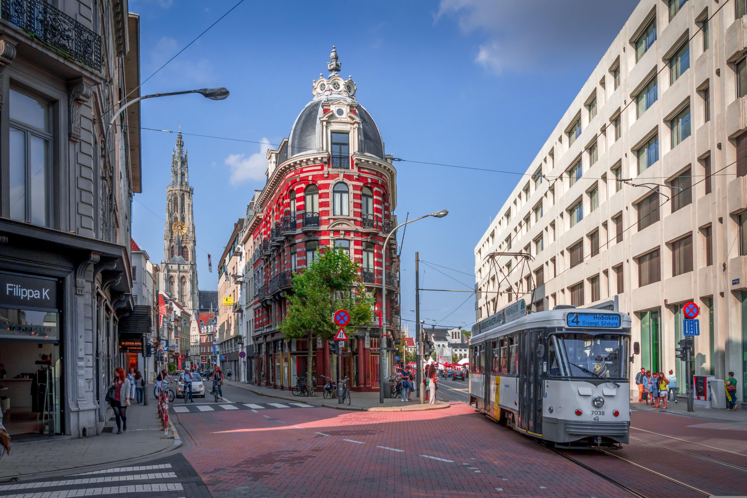 Antwerpen, Altstadt – Alte Straßenbahn vor historischen Häusern mit Kathedralturm im Hintergrund, Belgien