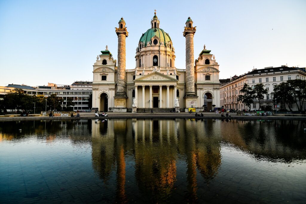 Karlskirche Wien – Barocke Kirche mit Kuppel und Säulenportikus, reflektiert im Wasser, Österreich