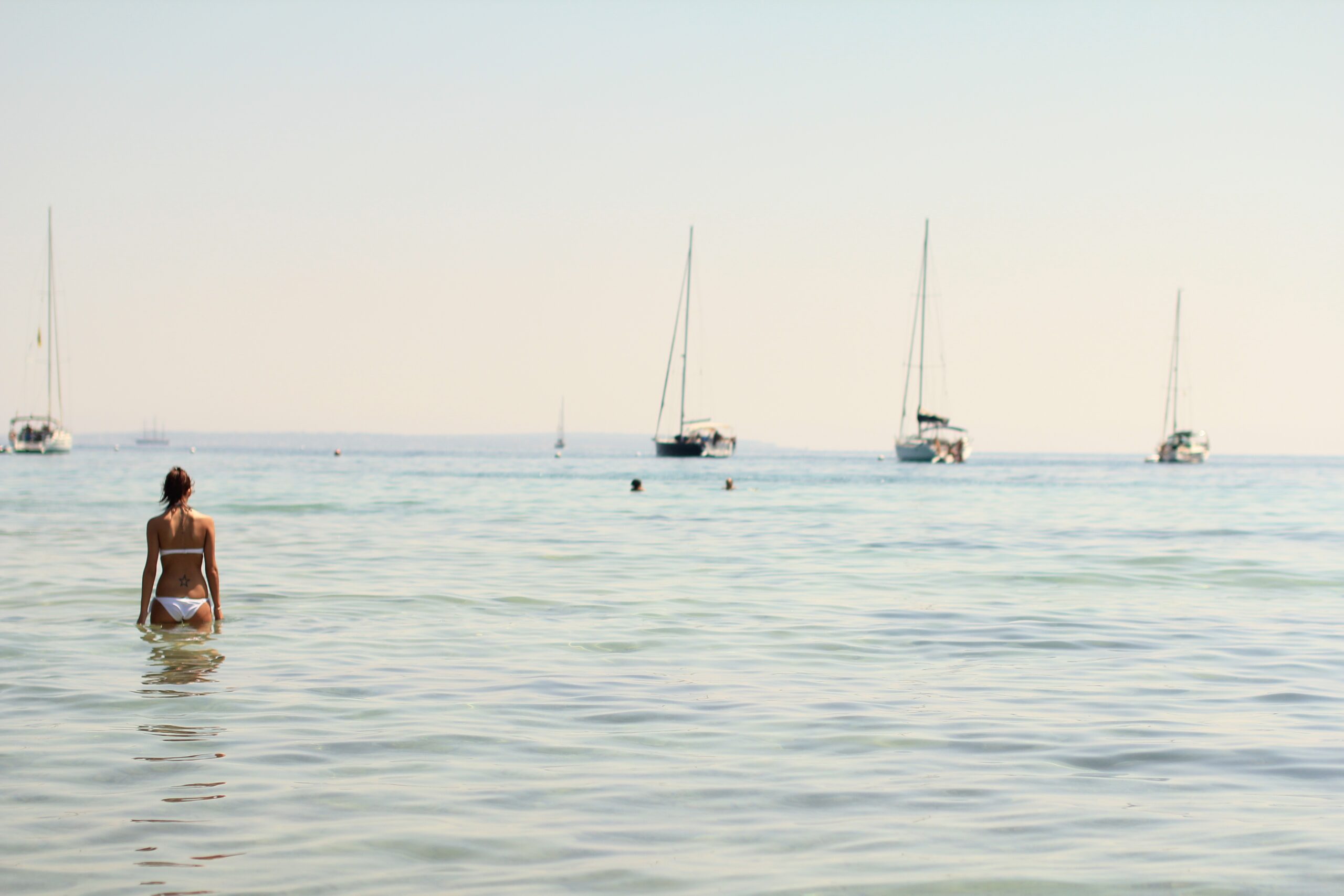 Strand auf Ibiza – Karibikähnliches Wasser und Boote, Spanien