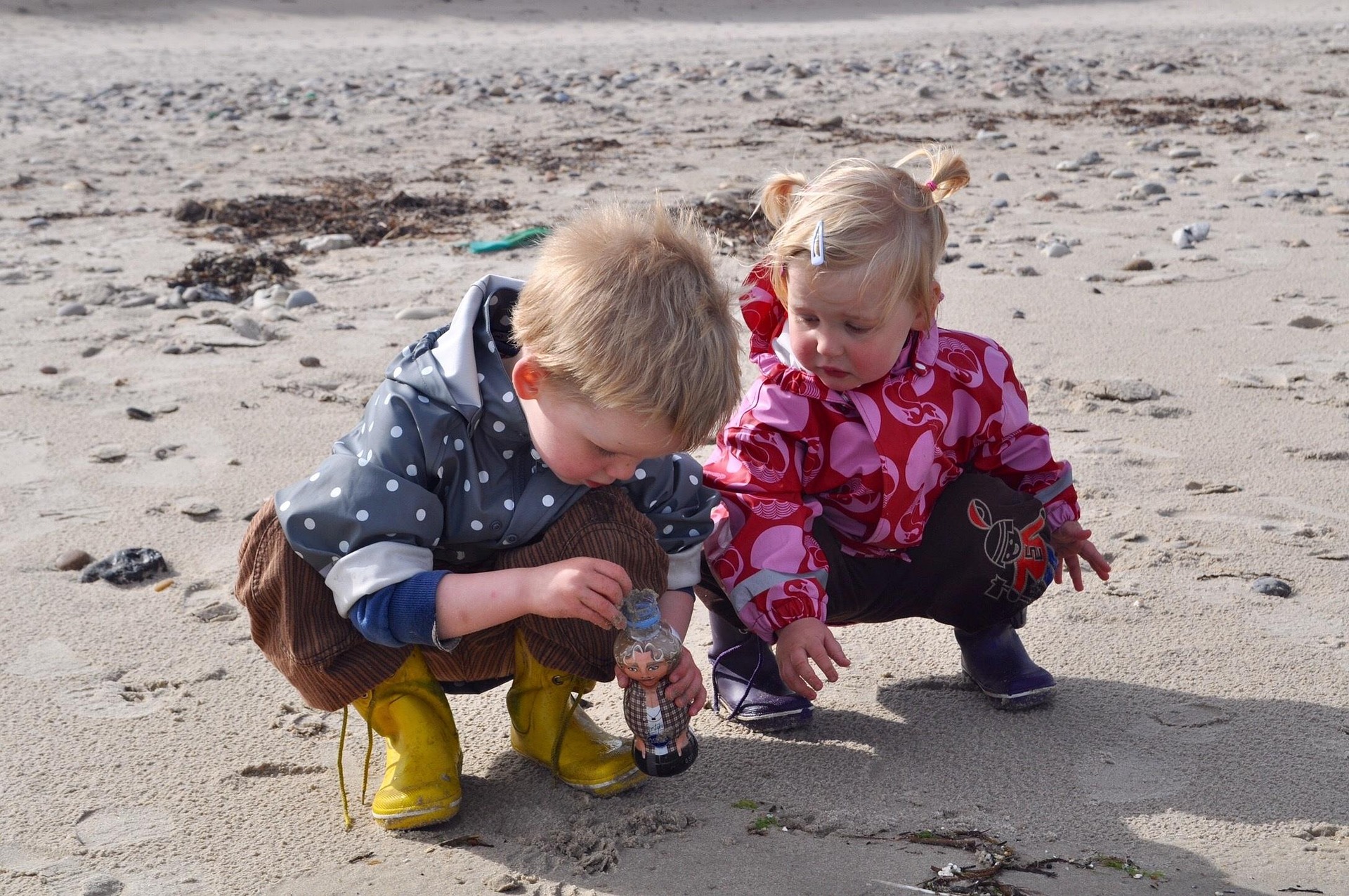 Spielende Kinder an der dänischen Küste mit Sand und Flaschen, Dänemark
