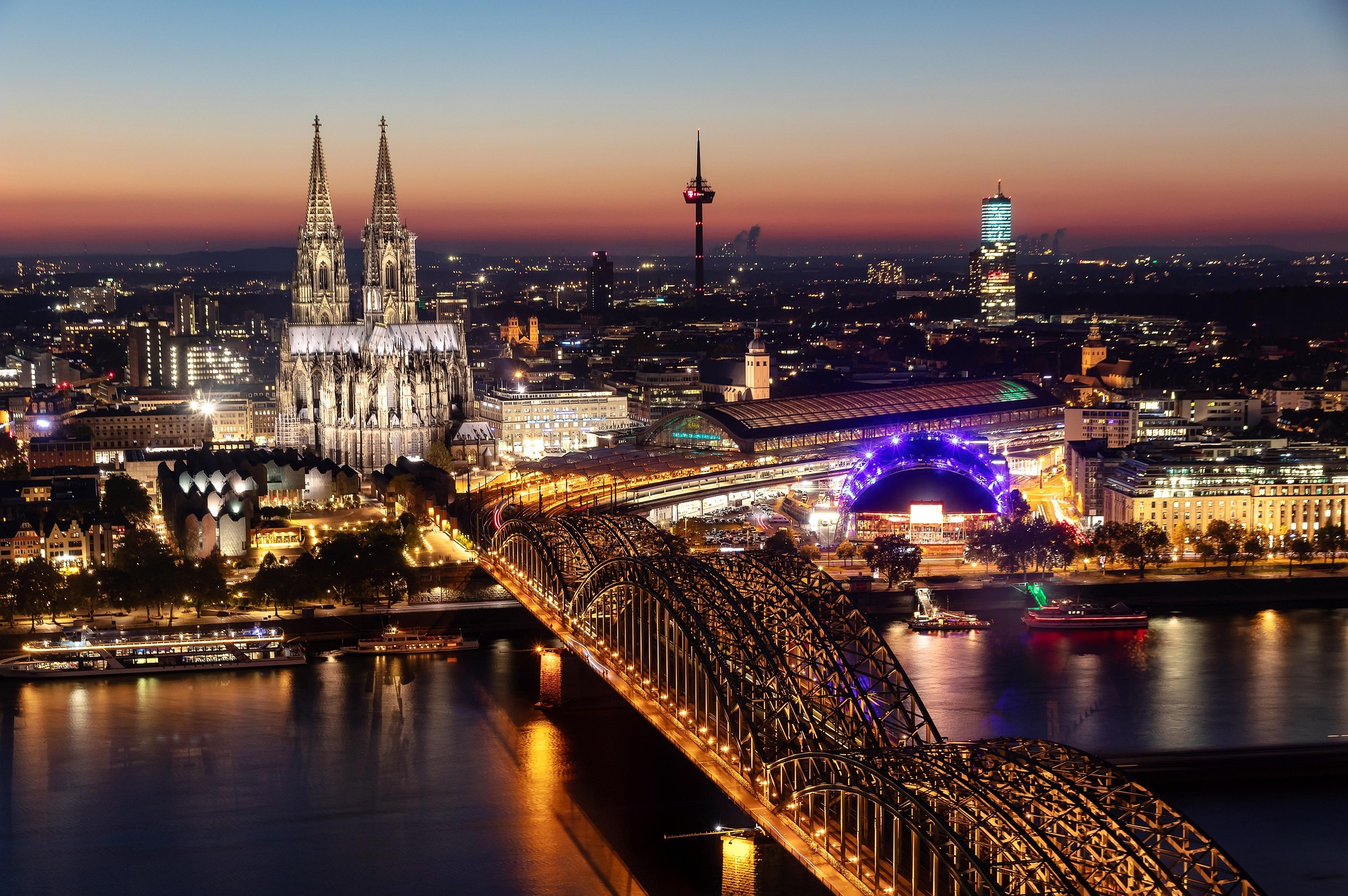 Köln – Nächtliche Vogelperspektive auf den beleuchteten Kölner Dom, die Hohenzollernbrücke und die Altstadt am Rhein, Nordrhein-Westfalen, Deutschland