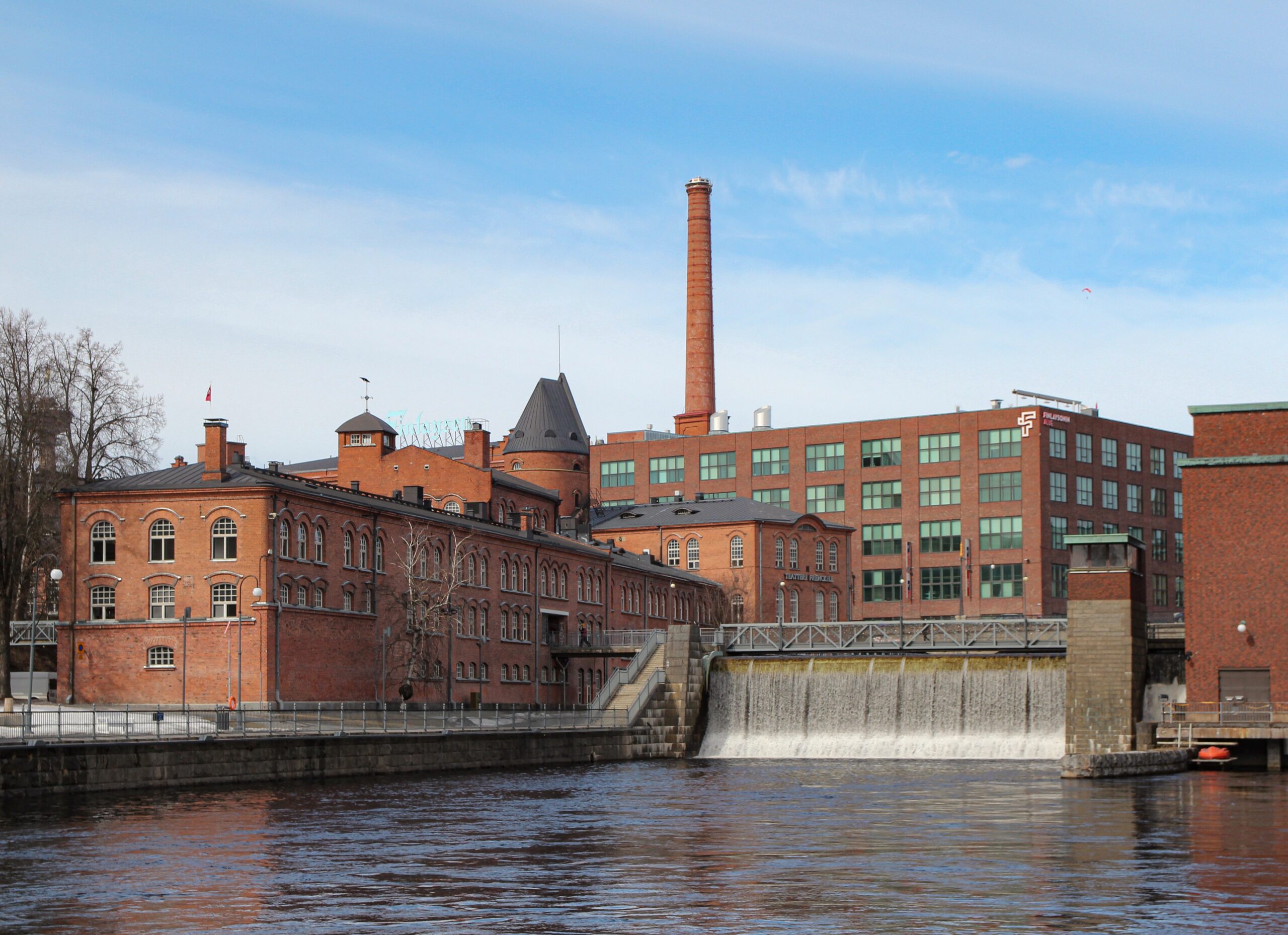 Finlayson Fabrik Tampere – Finlayson Fabrikareal mit rotem Backsteingebäude am Flussufer, Finnland