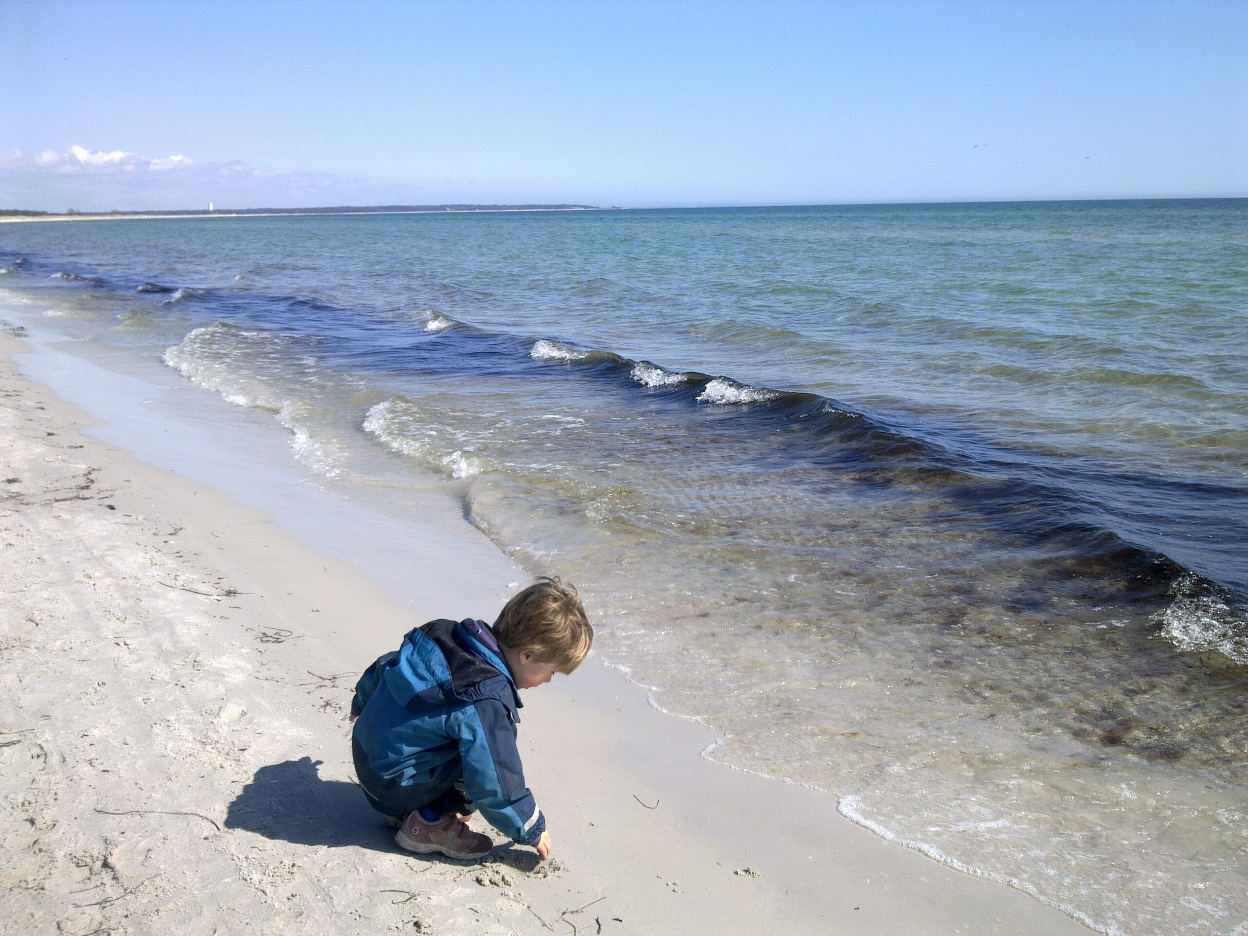 Schweden – Kind im Sand an der Küste spielend